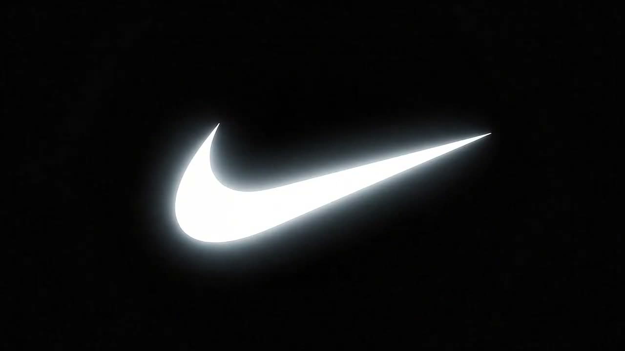 Create a sleek futuristic product ident on a pure black background. A glowing Nike logo hovers at center frame. The logo pulses brighter, then explodes into white light.

From the fragments, a minimal futuristic display stand self-assembles: clean white panels, glowing edges, and clothing racks unfolding with smooth mechanical precision. Keep surfaces reflective and photorealistic.

Camera begins as a static centered close-up on the logo, rapidly pushes out during the explosion, then transitions into a slow orbit around the completed stand. Use a 35mm cinematic look at 24fps.

Sound design: deep electronic pulse before explosion, sharp burst impact, then refined futuristic assembly sounds over a minimal electronic beat that rises with confidence.

Lighting should shift from high-contrast black into a bright white minimal showroom atmosphere. End with the glowing Nike logo above the completed apparel display in a clean, bold, futuristic scene. No subtitles and no text overlays.