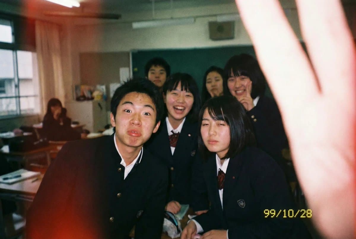 An everyday classroom snapshot taken with a disposable film camera, featuring natural film grain, authentic flash, and youthful school-life energy. It should feel like a spontaneous moment captured by a Japanese high school student, with natural composition, a clear subject, and clean details.
