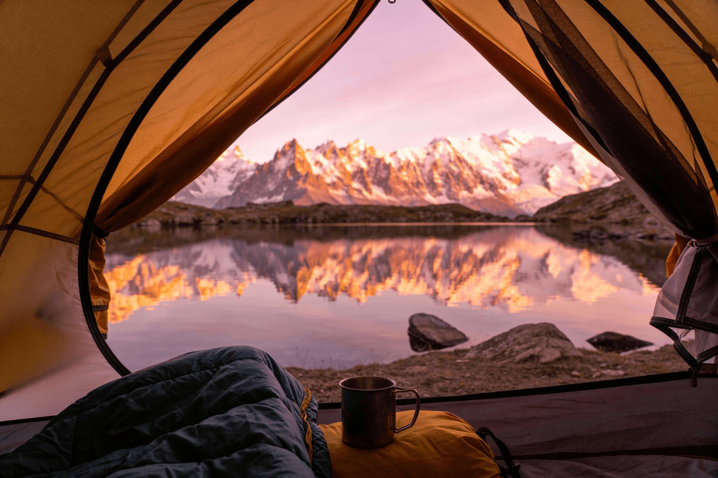 A stunning photo that looks like you are inside a tent, looking out at the majestic mountain scenery at dawn. The openings of the tent framed clear mountain lakes and snowy peaks stained red by the rising sun. The interior of the tent is cozy and comfortable, with sleeping bags and metal camping cups visible. This requires sophisticated spatial understanding and the ability to seamlessly blend indoor and outdoor scenes.